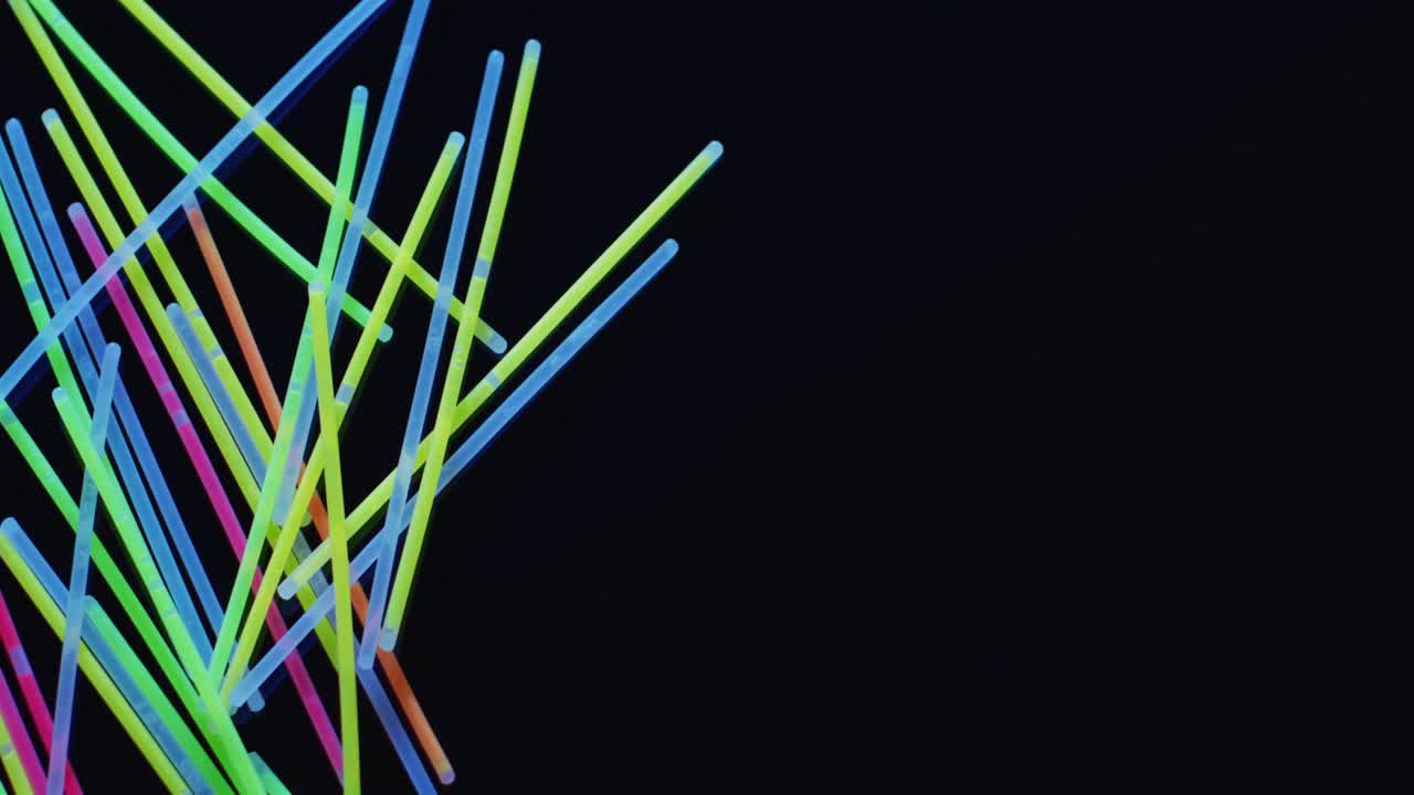 animación de múltiples palos de brillo de neón coloridos sobre fondo negro con espacio de copia