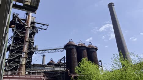 Hochofen-Für-Die-Stahlproduktion-Mit-Großen-Alten-Silos-Oder-Tanks,-Vielen-Rostigen-Rohren-Und-Metallgerüsten-Im-Landschaftspark-Duisbrug-Nord-Bei-Sonnenschein-In-Deutschland