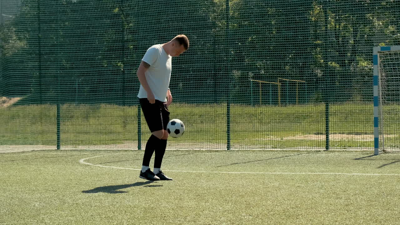 화창한 날 거리 축구 경기장에서 공을 가지고 프리스타일 트릭을 훈련하는 젊은 축구 남자 3