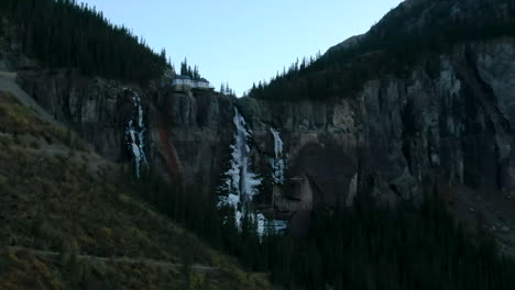 Telluride-Colorado-aerial-drone-Bridal-Veil-Falls-frozen-ice-waterfall-autumn-sunset-cool-shaded-Rocky-Mountains-Silverton-Ouray-Millon-Dollar-Highway-historic-town-scenic-landscape-parallax-zoom