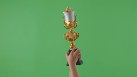 woman holding a champion golden trophy. green screen background