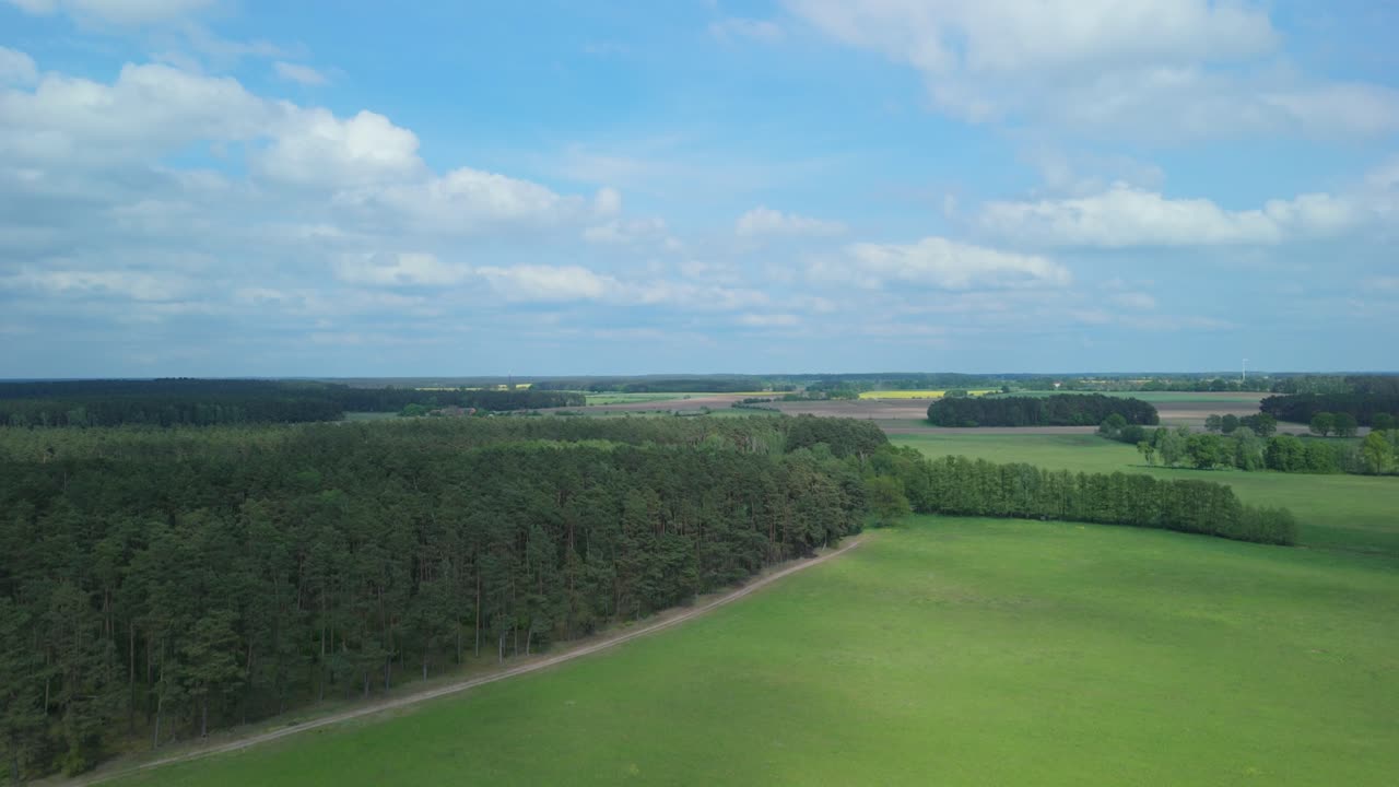 울창한 초록색, 울불한 숲, 은 하 구름으로 가득 찬 밝은 파란 하늘을 특징으로하는 광활한 시골 풍경의 조용한 공중 풍경.