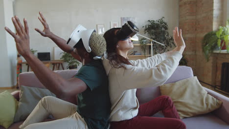 couple multiethnique jouant à un jeu vidéo avec des lunettes vr à la maison