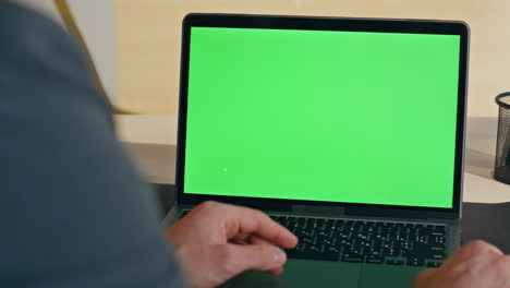 worker hand scrolling touchpad green screen laptop at modern workplace closeup