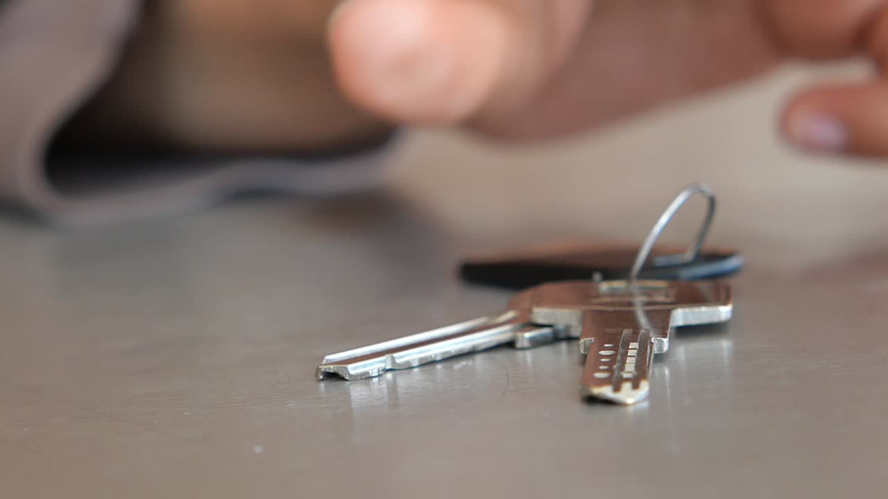 A person's hand picking up a set of keys