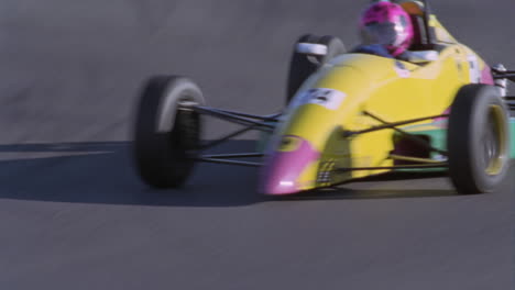 a racing car makes a turn on a track as a man watches