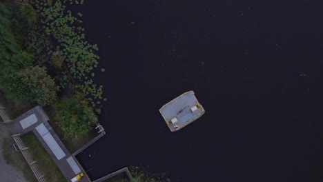 young woman is driving the bicycle ferry during sunset, aerial