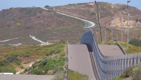 a border patrol vehicle moves along the border wall between san diego and tijuana 3