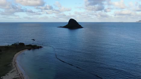 drone flying towards a mini island within hawaii