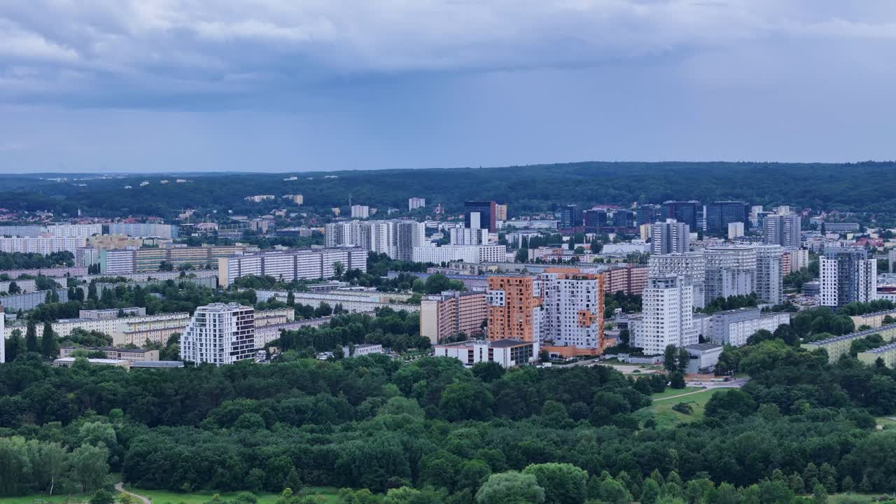 Gdansk Zaspa district in Poland, featuring residential buildings and green areas under a cloudy sky, showcasing urban planning and nature integration, drone flying forward