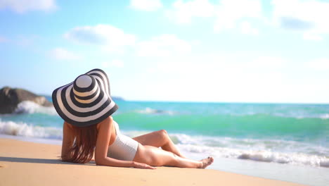 Mujer-Morena-Caucásica-Irreconocible-Con-Un-Sombrero-De-Sol-Flojo-Tirado-En-El-Paseo-Marítimo-De-Arena-Cuando-Las-Olas-Espumosas-Ruedan-Hacia-Sus-Pies,-Plantilla-De-Espacio-De-Copia-De-Vacaciones