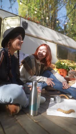 friends enjoying an autumn picnic near a trailer