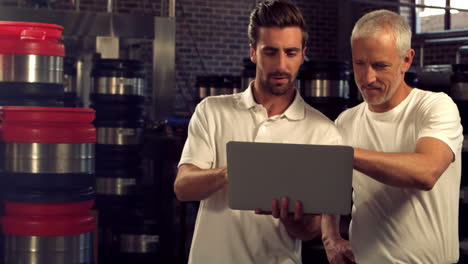 Brewery-workers-checking-info-on-a-laptop