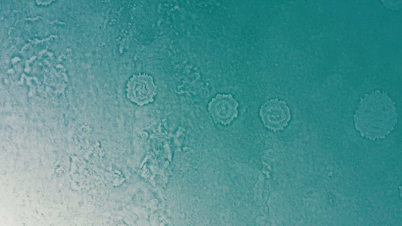Aerial Rotate down over frozen lake showing circular patterns on ice