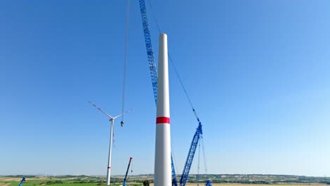 crane at the construction site of wind turbine in austria - aerial drone shot