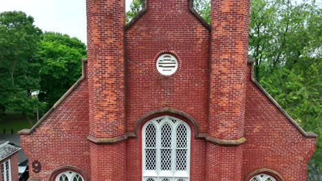 rising shot of tall historic brick building with windows and lattice