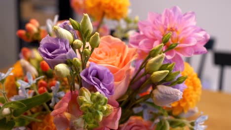 un hermoso ramo de bodas compuesto de flores de color naranja, rosa, púrpura y verde