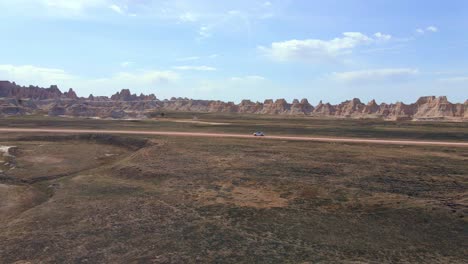 SUV-Fährt-Allein-Auf-Einer-Unbefestigten-Straße-Im-Badlands-Nationalpark,-South-Dakota