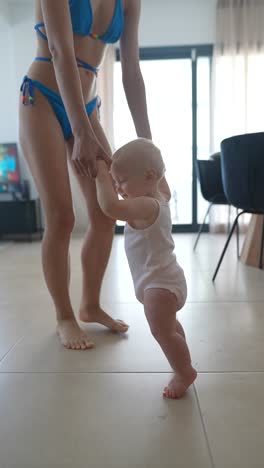 mother helping baby learn to walk