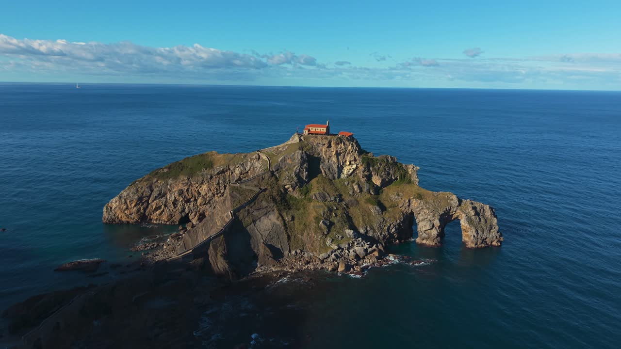 San Juan de Gaztelugatxe con gradini in pietra, paesaggio costiero e luce del sole del tardo pomeriggio, drone. Spagna