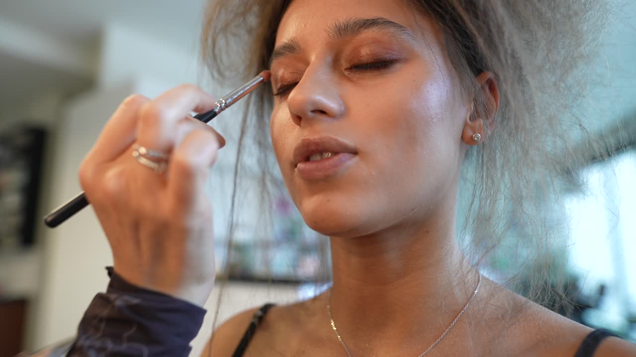 Young Woman Getting Eyeshadow Applied with a Brush