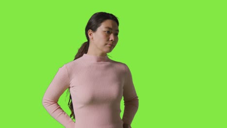 스튜디오 초상화 슬픈 불행하거나 걱정 된 여성이 녹색 화면 앞에 서 있습니다