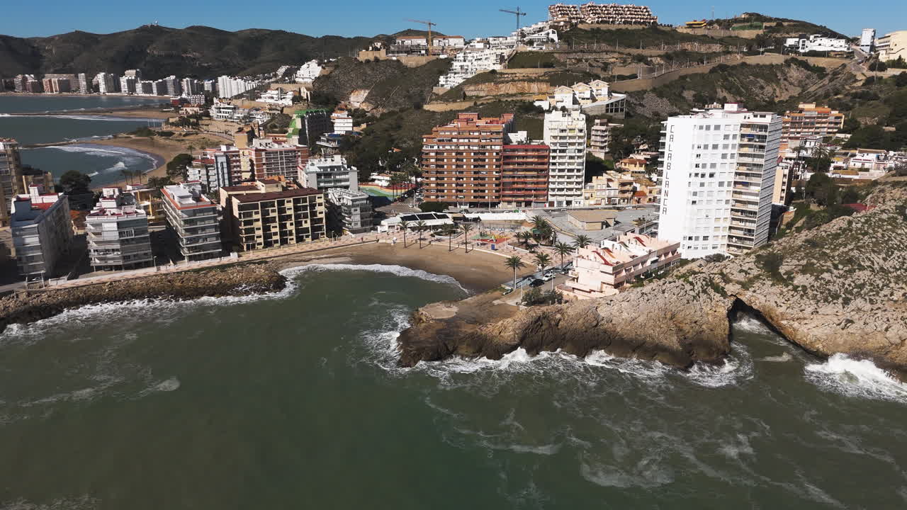 Aerial descent over rooftops with beach fading into horizon of morning sky