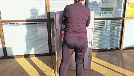 una mujer de mediana edad vota en las elecciones dejando caer una carta por correo en la ranura de la casilla de votación oficial.