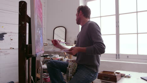 male artist working on painting in studio shot on r3d