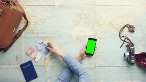 Top-view-woman-traveler-hands-planning-holiday-using-mobile-phone-app-vintage-desk-from-above---Red-Epic-Dragon