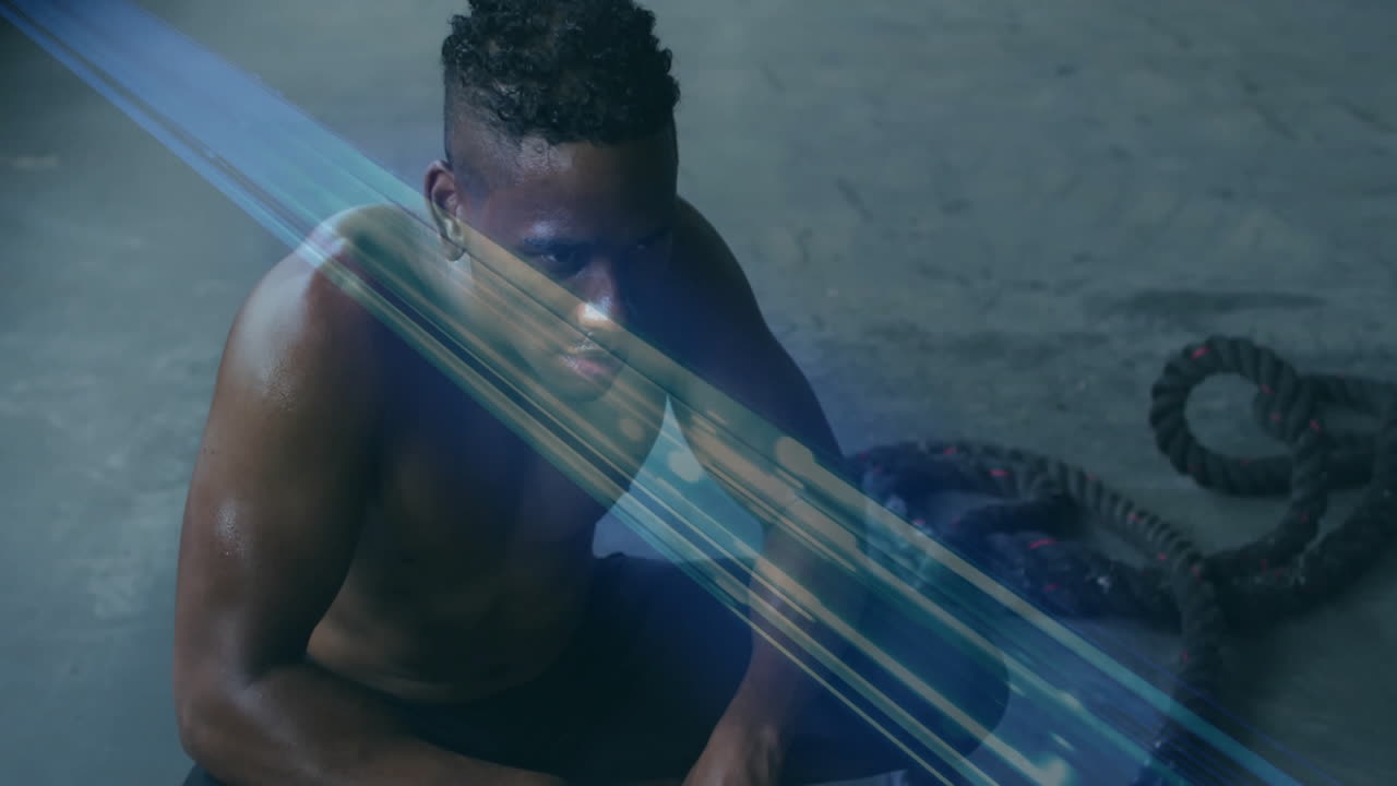 Sitting on floor, man surrounded by crossing blue light beams in animation