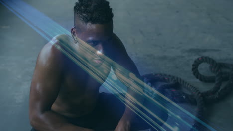 sitting on floor, man surrounded by crossing blue light beams in animation