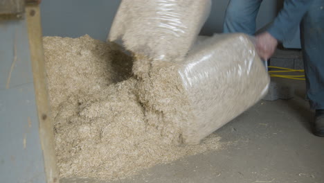 A-farm-worker-cuts-open-a-plastic-container-of-straw-and-spreads-it-on-the-floor