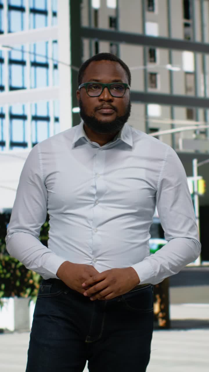 Vertical Video Portrait of african american man walking on downtown sidewalk near busy avenue