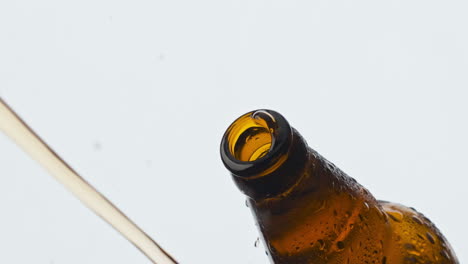 cider splashing misted flask closeup. cold lager beverage foaming fountaining