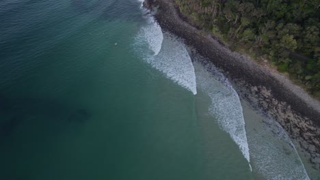 vista aérea de los surfistas en la playa de little cove cerca del parque nacional de noosa en queensland, australia