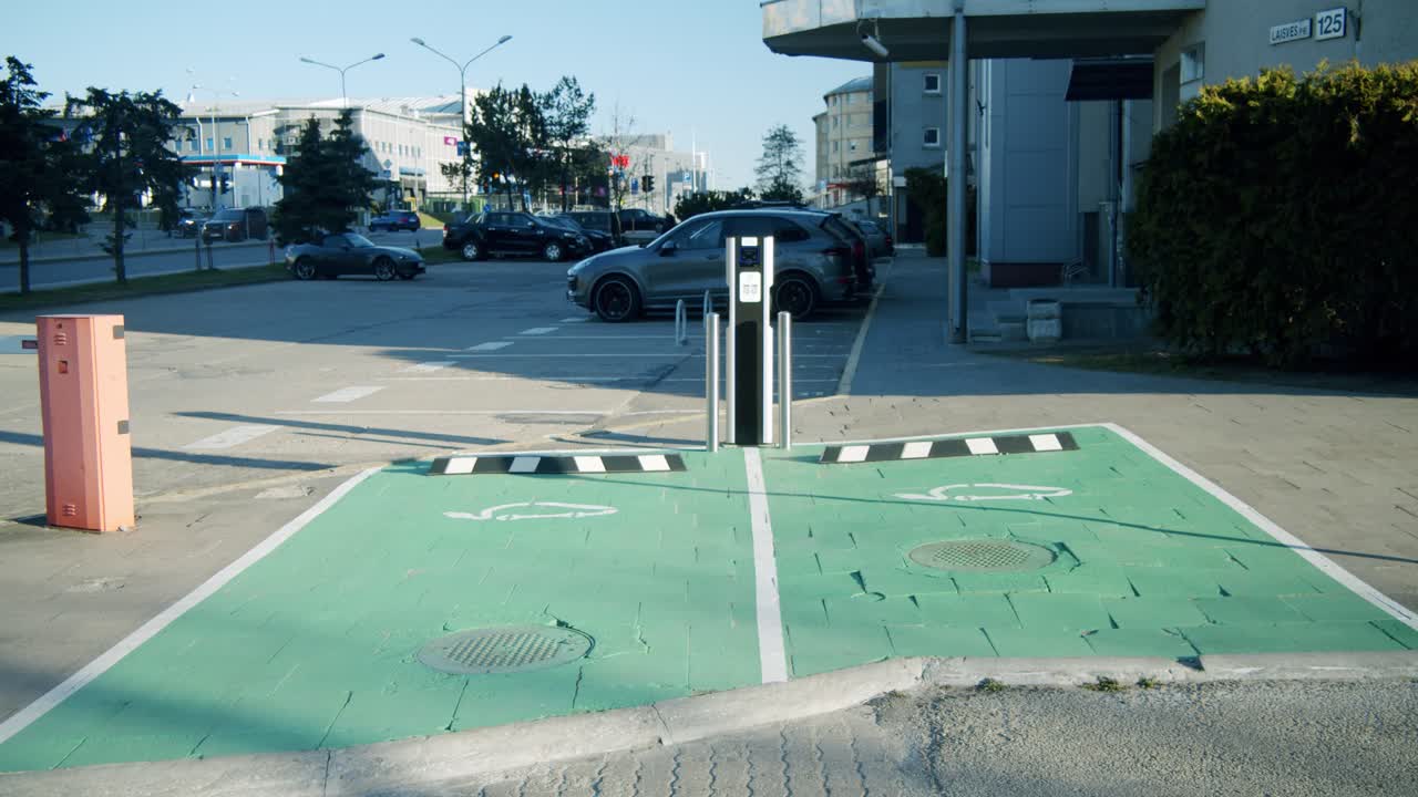 Two Empty Parking Spaces with a Charging Station for Electric Vehicles on a Sunny Day