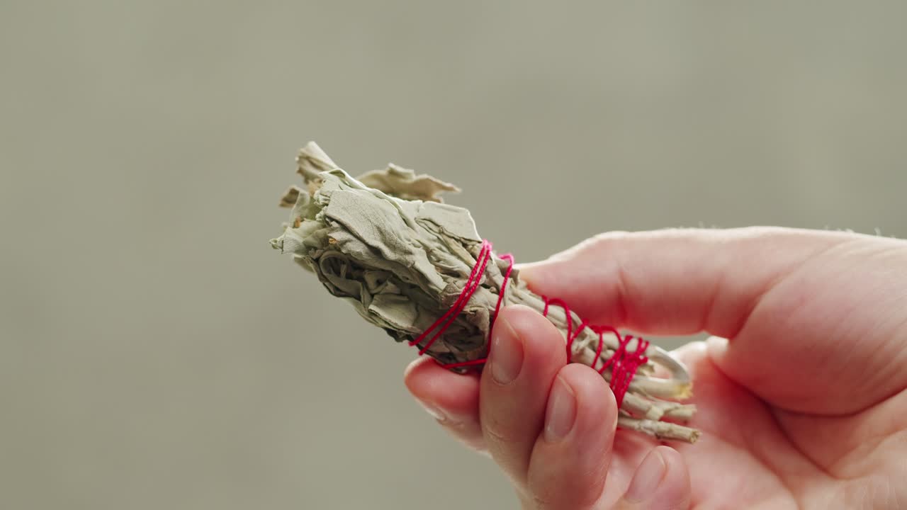 Person holding Palo Santo wood stick in hand, aromatic Palo Santo burning on black background, smoke spreading around, slow motion video clip, high quality 4k close up footage. High quality 4k footage