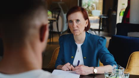 close-up of a woman listening attentively during a discussion in a cafe