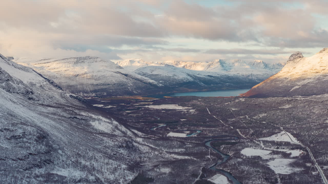 4K drone-timelapse med fremadgående zoom over norske fjelde i et frodigt arktisk vinterlandskab under solnedgang