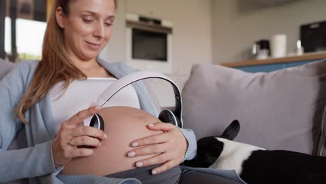 Mujer-Embarazada-Sosteniendo-Auriculares-En-El-Vientre.