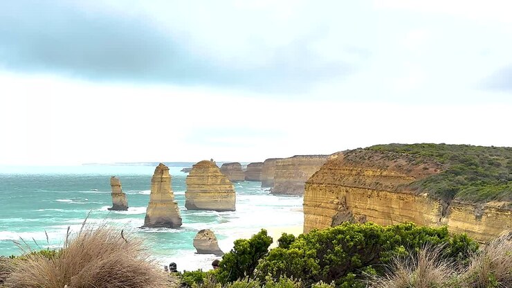 Una vista panorámica de los Doce Apóstoles a lo largo de la Great Ocean Road de Australia, capturada con luz natural y olas oceánicas dinámicas.