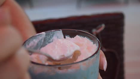 girl eating whipped cream from the top of the coffee with a long silver spoon