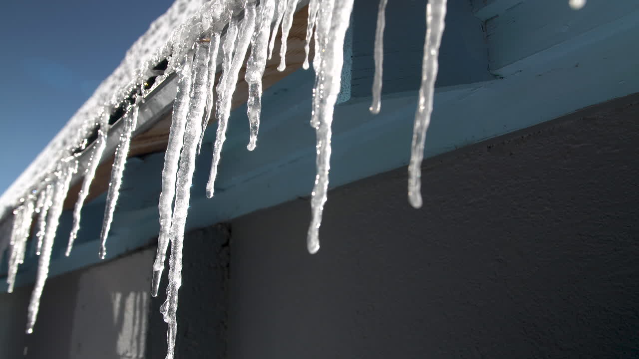 Icicles dripping on the edge of a roof