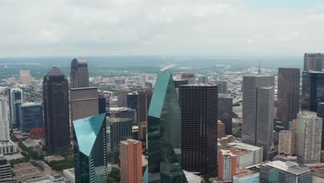 Reenvía-Drones-Voladores-Hacia-Modernos-Edificios-Altos-En-El-Lugar-De-La-Fuente-Con-Fachadas-De-Vidrio-Y-Forma-Irregular.-Vista-Aérea-Del-Centro.-Dallas,-Texas,-Nosotros