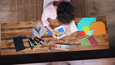 woman creating art on a wooden table