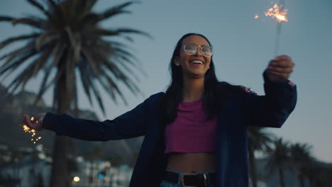 beautiful teenage girl with sparklers dancing on beach at sunset celebrating having fun independence day celebration with fireworks enjoying 4th of july freedom