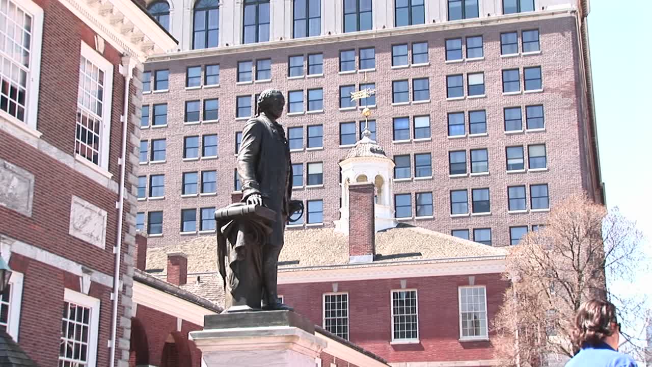 una estatua de george washington se encuentra frente al salón de la independencia