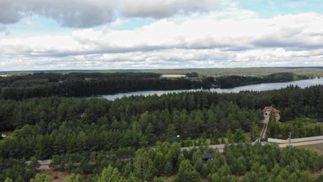 panoramic aerial shot of crop fields, forest and a lake in rural area of borowy młyn in kaszuby, pomorskie, poland