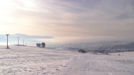 vista bloqueada sobre el paisaje de nieve de invierno abierto con la ciudad en la distancia